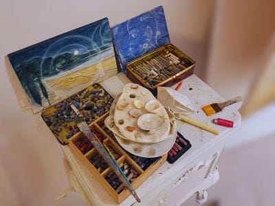 Artist workspace in Santorini with paints and handmade materials, showing a local creative process