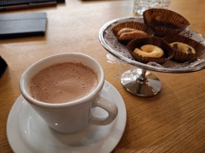 Coffee and local sweets on a table in Santorini, suggesting a relaxed planning conversation