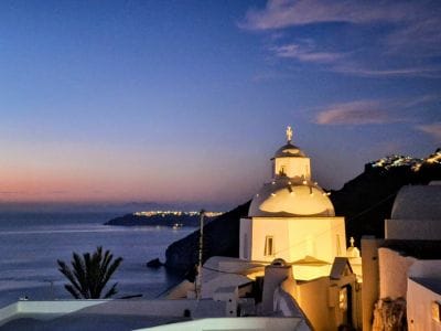 Santorini church at sunset with warm light and calm atmosphere overlooking the sea